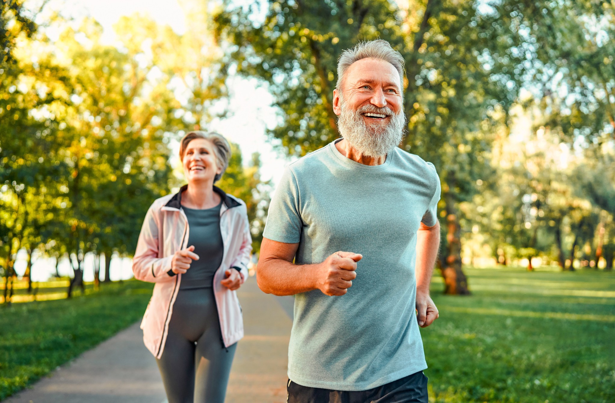 Älteres Paar joggt gemeinsam durch einen Park
